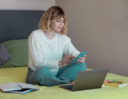 Junge Frau nutzt ihr Smartphone zur Selbstanlage