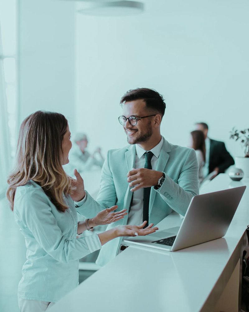 People talking at desk with laptop
