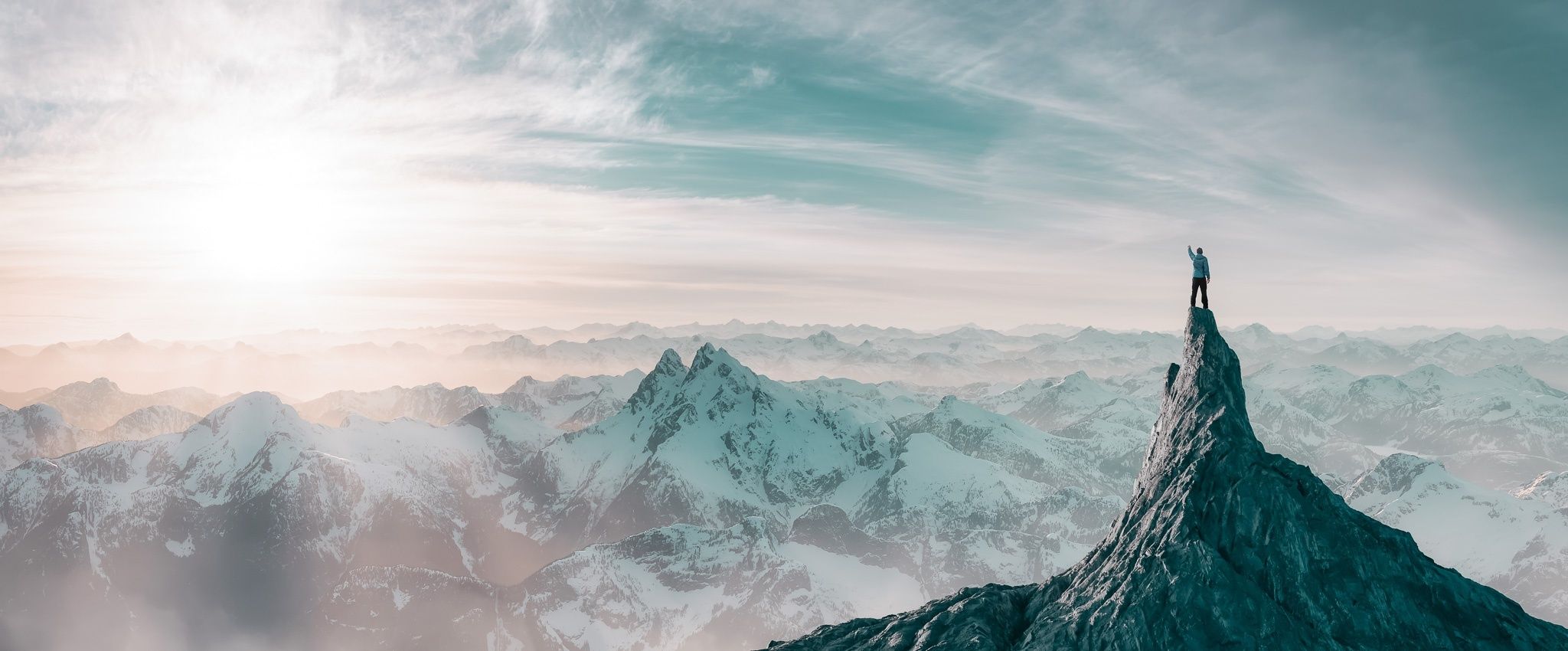 Gebirgskette mit einem Bergsteiger am Gipfel